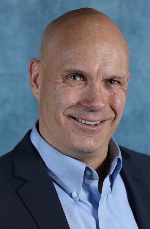 Ted Leppzer, founder of Vikasa Strategic Partners, smiling in a navy blazer and light blue shirt